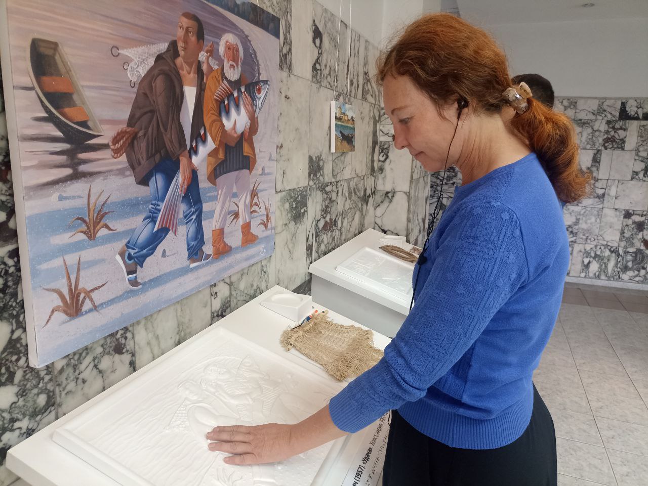 Комментарий к изображению: посетительница выставки осматривает тактильную модель картины.1957 года "Удача"